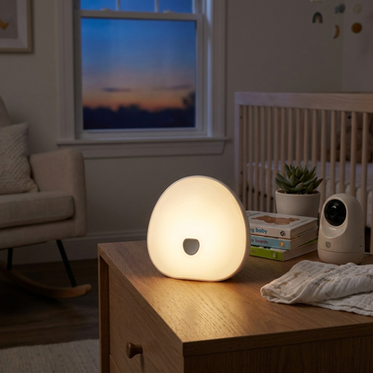 White noise machine glowing softly on nursery nightstand